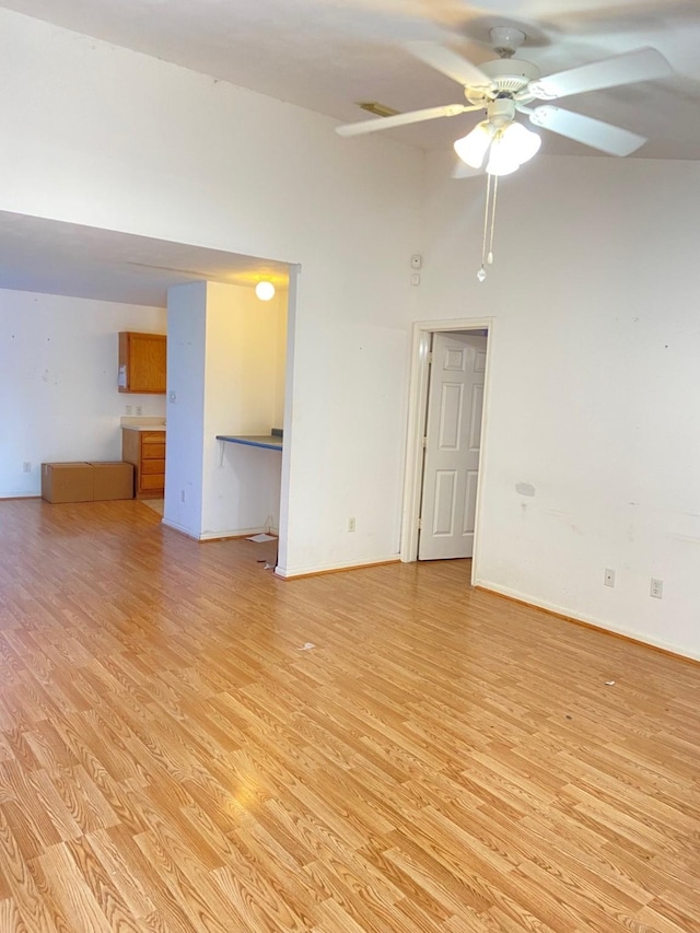 spare room featuring light wood-type flooring, ceiling fan, and baseboards