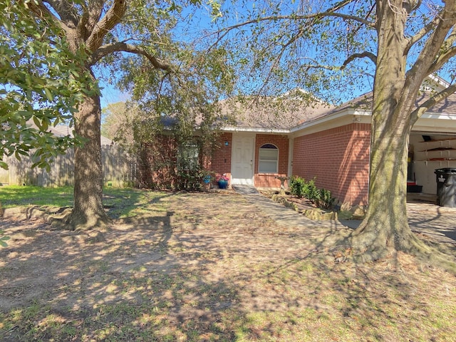 ranch-style home featuring brick siding and fence