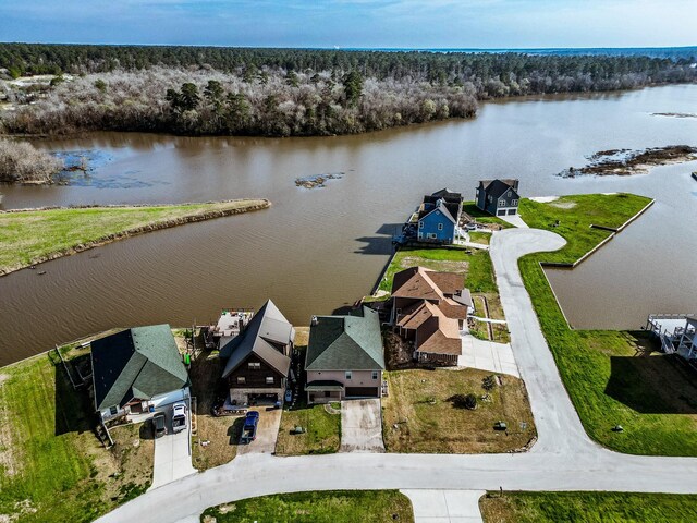 drone / aerial view featuring a water view, a forest view, and a residential view