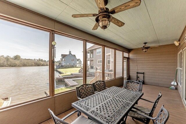 sunroom / solarium with a water view and ceiling fan