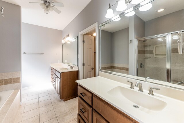 bathroom featuring tile patterned flooring, a garden tub, a sink, two vanities, and a stall shower