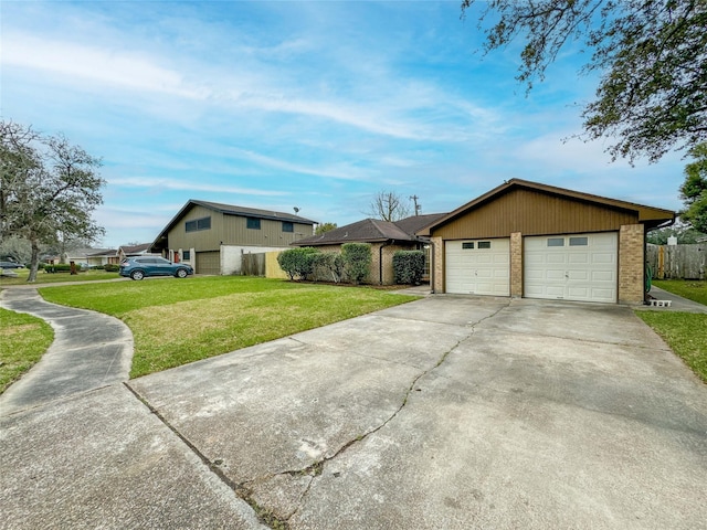 view of front of house featuring a front yard, a detached garage, and brick siding