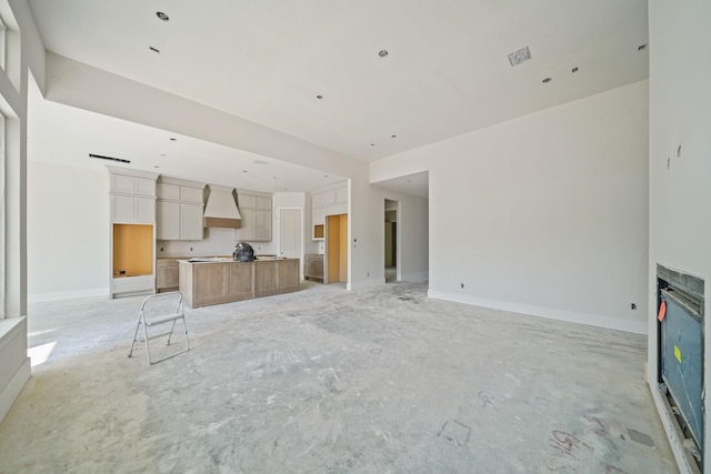 unfurnished living room with a glass covered fireplace, visible vents, and baseboards