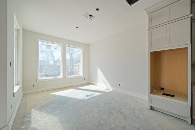 unfurnished bedroom with baseboards and unfinished concrete floors