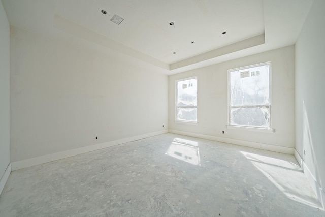 unfurnished room featuring a raised ceiling, visible vents, and baseboards