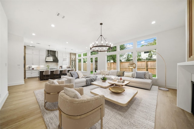 living area featuring light wood-type flooring, a fireplace, visible vents, and recessed lighting