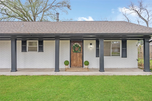 ranch-style home featuring brick siding, roof with shingles, and a front yard