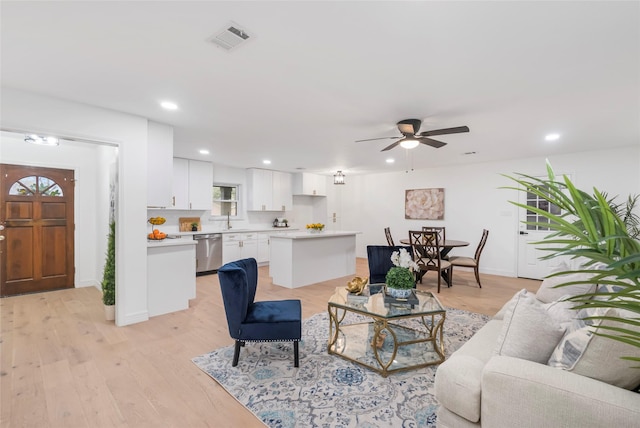 living room with light wood-style flooring, visible vents, ceiling fan, and recessed lighting