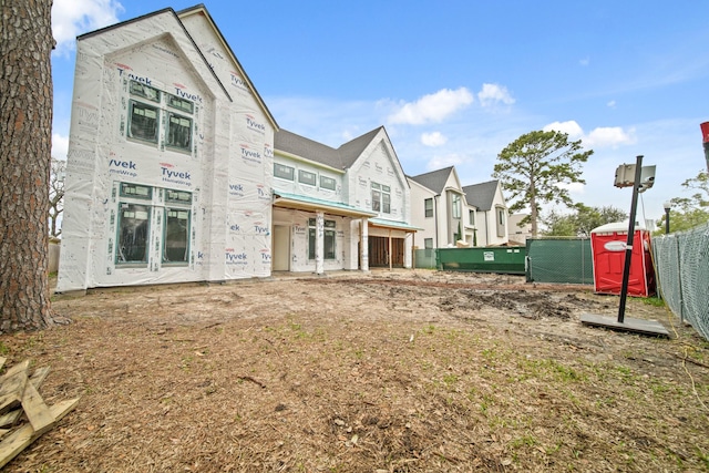 rear view of house featuring fence