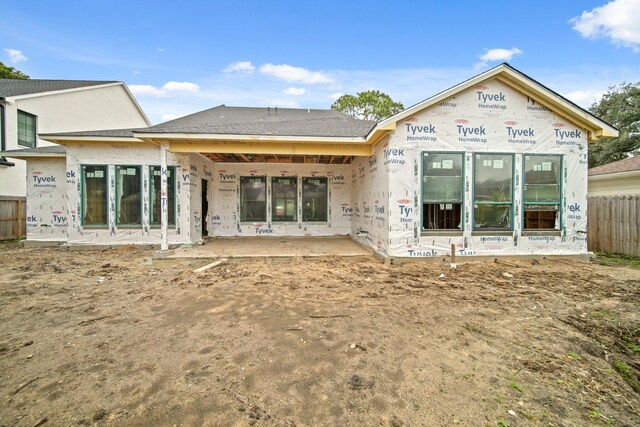 rear view of property featuring fence