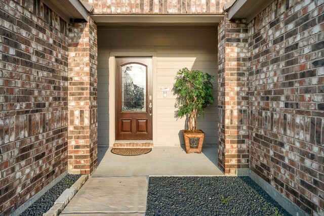 doorway to property with brick siding