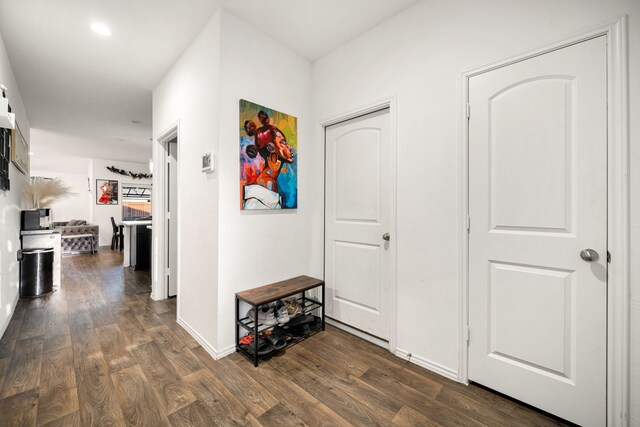 corridor featuring dark wood-style floors and baseboards