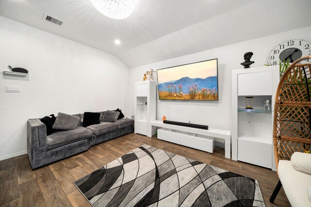 living area with dark wood finished floors, visible vents, vaulted ceiling, and a notable chandelier