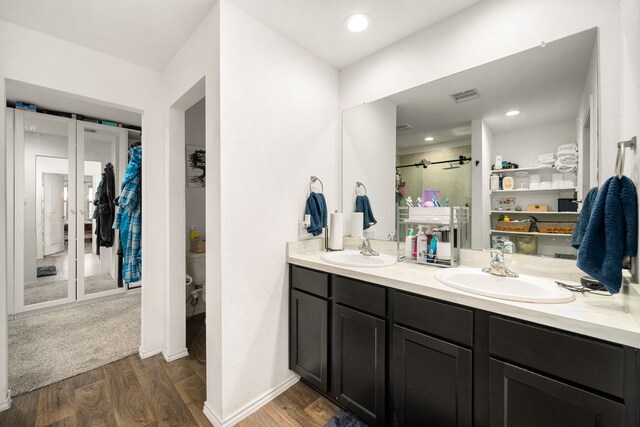 bathroom with visible vents, a sink, toilet, and wood finished floors