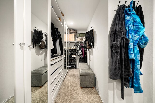 walk in closet featuring light carpet