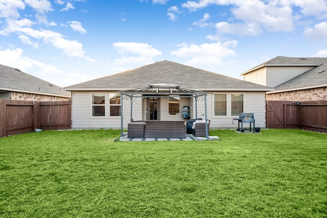 rear view of house with a fenced backyard, a lawn, an outdoor living space, and a gazebo