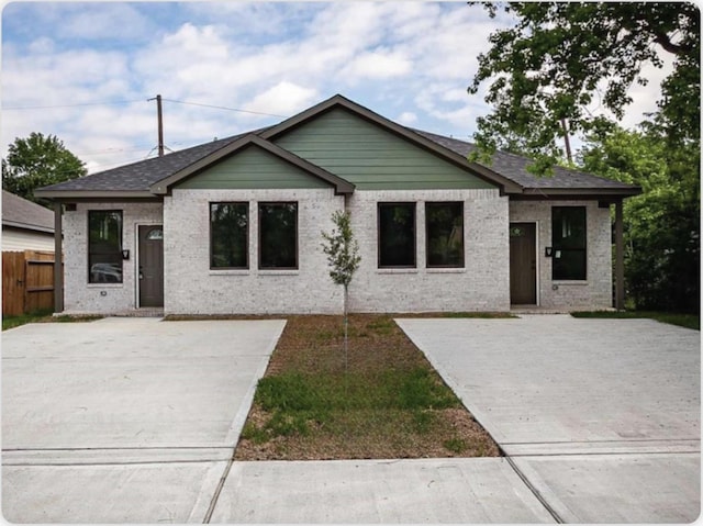 view of front of property featuring brick siding and fence