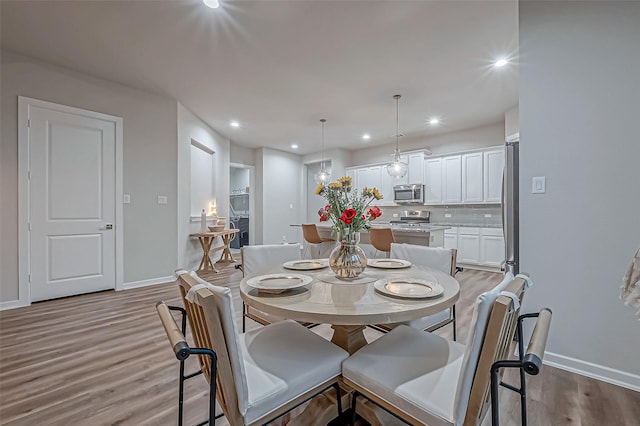 dining space featuring light wood-style floors, baseboards, and recessed lighting