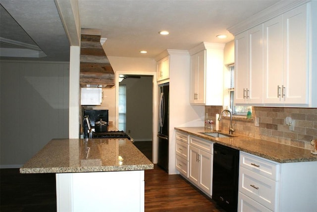 kitchen featuring black dishwasher, a sink, gas range, premium range hood, and fridge