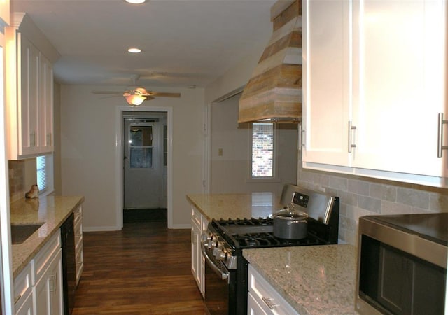 kitchen with stainless steel appliances, wall chimney exhaust hood, backsplash, and white cabinetry