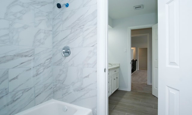 bathroom featuring baseboards, visible vents, shower / bathing tub combination, and vanity