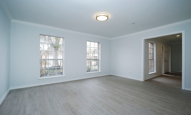 unfurnished room with baseboards, ornamental molding, and wood finished floors