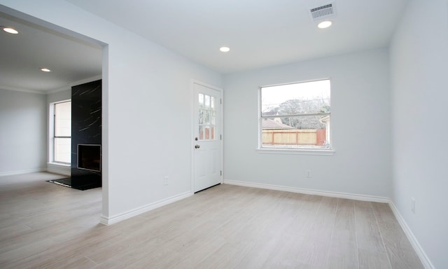 spare room featuring visible vents, plenty of natural light, and light wood finished floors