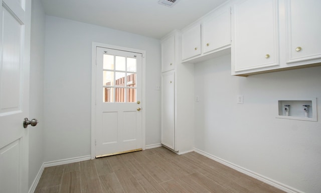 laundry area featuring light wood-type flooring, cabinet space, baseboards, and washer hookup