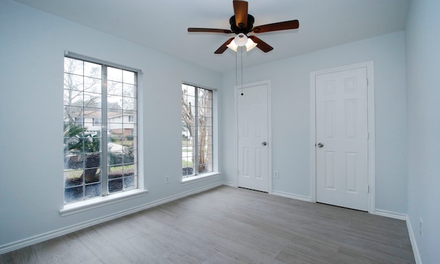 spare room featuring a ceiling fan, baseboards, and wood finished floors