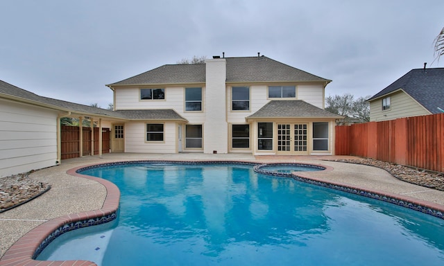 view of pool featuring a patio area, a fenced backyard, and a pool with connected hot tub