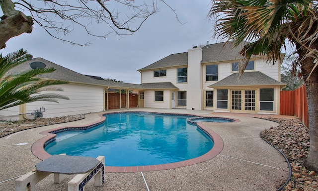 view of pool featuring a patio area, fence, a fenced in pool, and an in ground hot tub