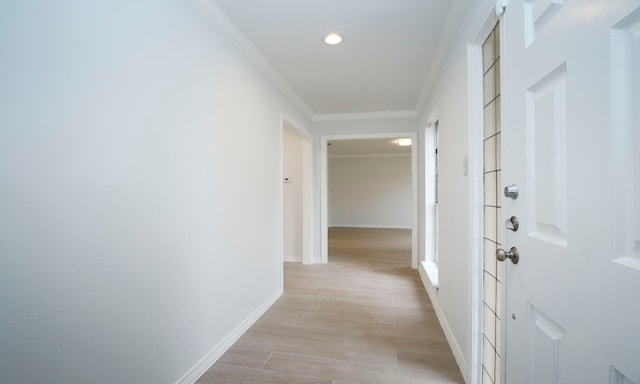 corridor featuring light wood-style flooring, ornamental molding, baseboards, and recessed lighting