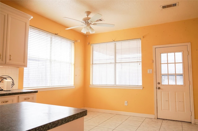 kitchen with plenty of natural light, tasteful backsplash, dark countertops, and visible vents