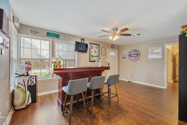 bar featuring a dry bar, baseboards, visible vents, and dark wood-style flooring