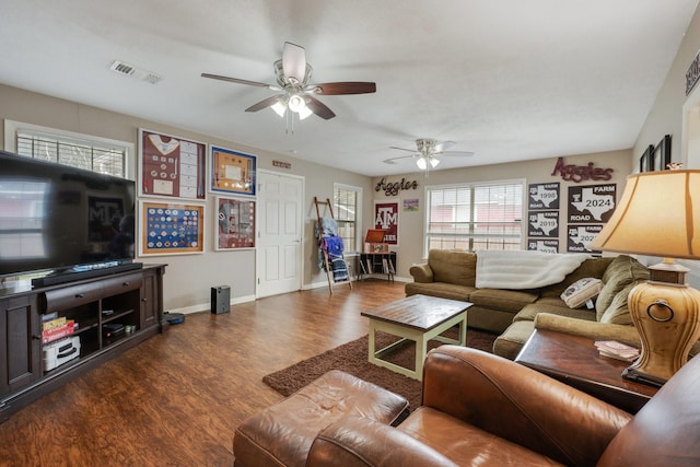 living area featuring baseboards, visible vents, ceiling fan, and wood finished floors