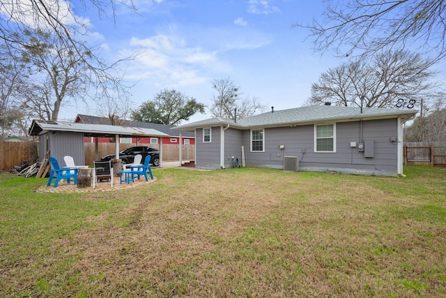 back of property featuring fence, central AC unit, a carport, and a yard