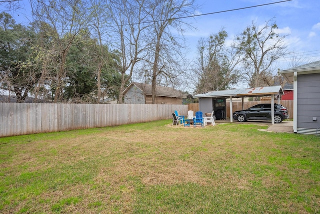 view of yard featuring a carport and a fenced backyard