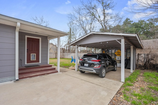 view of car parking with entry steps, concrete driveway, fence, and a detached carport