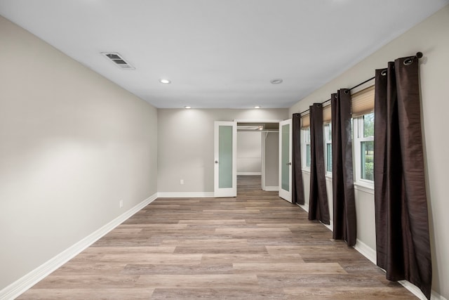 spare room featuring light wood-style flooring, visible vents, baseboards, and recessed lighting