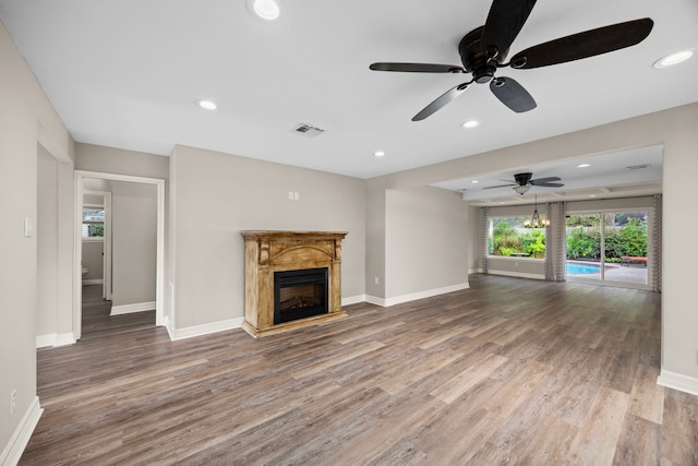 unfurnished living room featuring recessed lighting, wood finished floors, visible vents, and baseboards