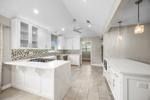 kitchen with a peninsula, stainless steel appliances, white cabinetry, hanging light fixtures, and glass insert cabinets