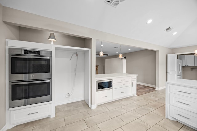 kitchen with appliances with stainless steel finishes, pendant lighting, visible vents, and white cabinets