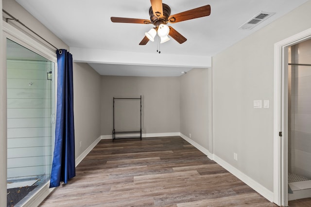 spare room featuring a ceiling fan, wood finished floors, visible vents, and baseboards