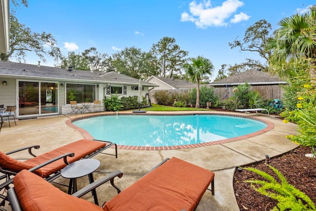 view of pool featuring a fenced in pool, a patio area, a fenced backyard, and a diving board