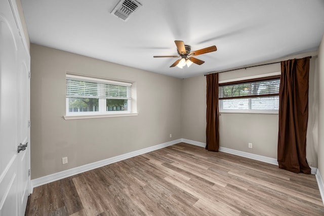 unfurnished room featuring baseboards, ceiling fan, visible vents, and light wood-style floors