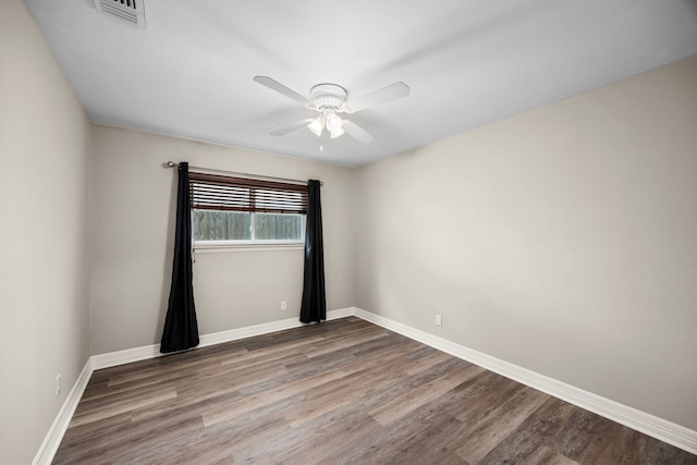 empty room featuring a ceiling fan, baseboards, visible vents, and wood finished floors