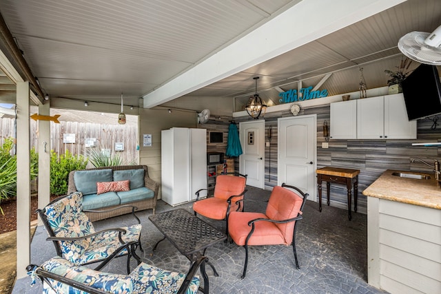 view of patio featuring fence, outdoor lounge area, and a sink