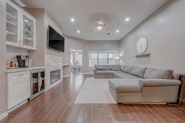 living room featuring wood tiled floor, beverage cooler, ceiling fan, and recessed lighting