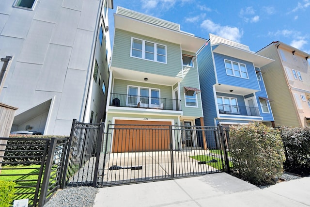 view of front facade with an attached garage, a fenced front yard, a gate, and concrete driveway