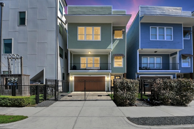 view of front of property with driveway, a fenced front yard, and an attached garage